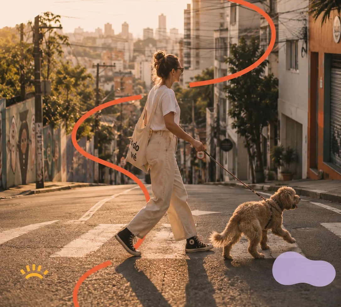 Woman crossing a leafy city street at golden hour, walking her dog